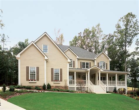 tan house with brown metal roof|tan siding with black shutters.